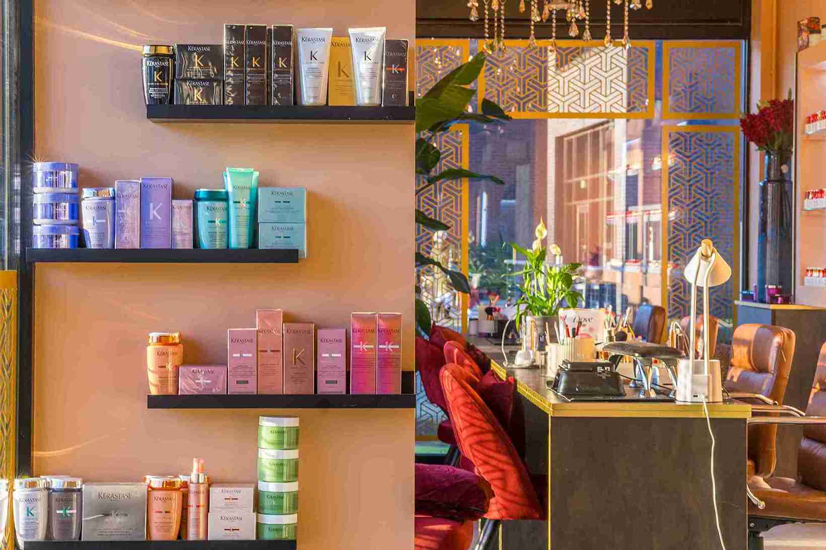 Curated floating shelves displaying an organized array of Kérastase luxury hair care products by color and line.